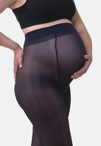 Collant premaman blu navy con una cintura morbida e elasticizzata. Il materiale è semi-trasparente e liscio, con una cucitura centrale sul retro.