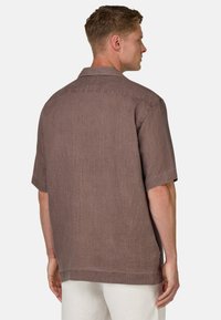 Camicia a maniche corte in lino marrone con finitura texturizzata, dotata di colletto classico e spacchi laterali per comfort e traspirabilità.