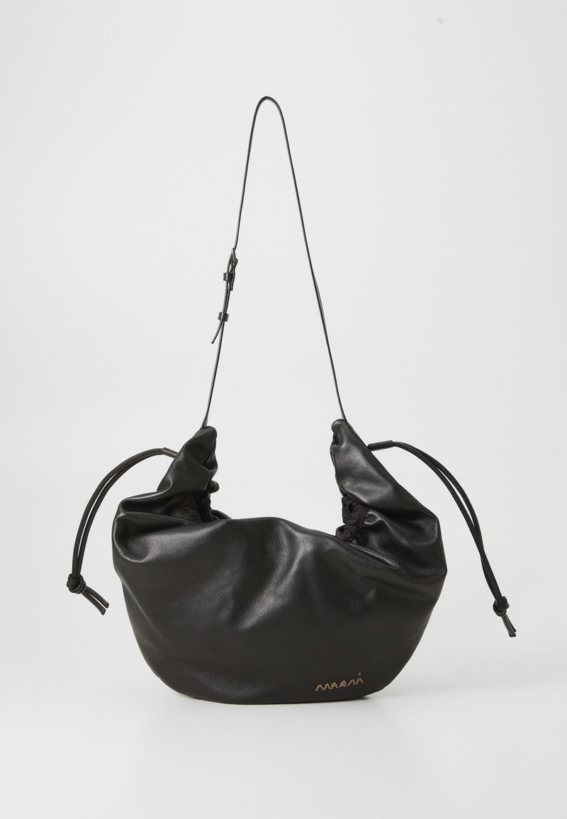 Borsa a spalla nera in morbida pelle con tracolla sottile regolabile, lati arricciati legati con nodi e piccolo logo dorato in basso a destra.