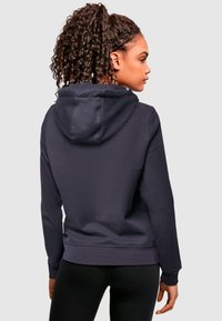 Marineblauwe hoodie met lange mouwen, ribgebreide manchetten en onderrand. Zacht materiaal met een gladde textuur en een verstelbare trekkoordkap.