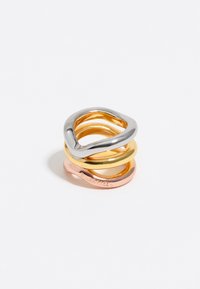 Tres anillos entrelazados en plata, oro y oro rosa. Superficies lisas y pulidas con un diseño ondulado y anchos variados. Grabado de marca notable.
