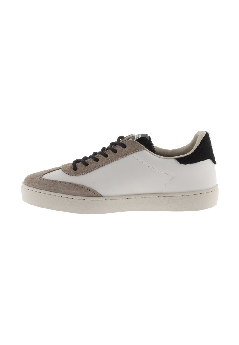 Sneaker a vita bassa in pelle bianca con dettagli in suede beige. Presenta lacci neri e un tallone nero testurizzato. Suola in gomma, design minimalista.