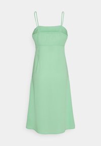 Vestido de alças em verde-claro, com um corpete justo, saia levemente godê e detalhes discretos de costura ao longo da gola e da bainha.
