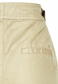 Beige Baumwollhosen mit glatter Textur, ausgestattet mit einer Gesäßtasche und Knopfverschluss. Schlichte Nähte entlang des Bunds und der Taschenränder.