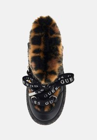 Botas de tobillo negras con borde de pelo sintético de leopardo, con cordones gruesos negros que presentan una marca en blanco y ojales de metal.