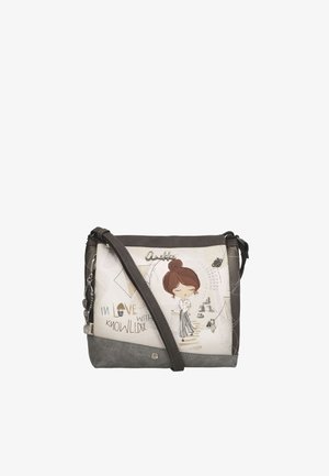 Piccola borsa a tracolla con una donna dei cartoni animati, libri e la frase "Innamorata della conoscenza" su sfondo beige e grigio.