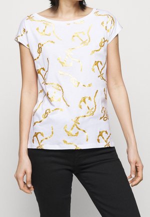 Biała koszula z krótkim rękawem w złoty wzór kotwicy i liny, noszona przez osobę w czarnych spodniach, tułów i ramiona widoczne.