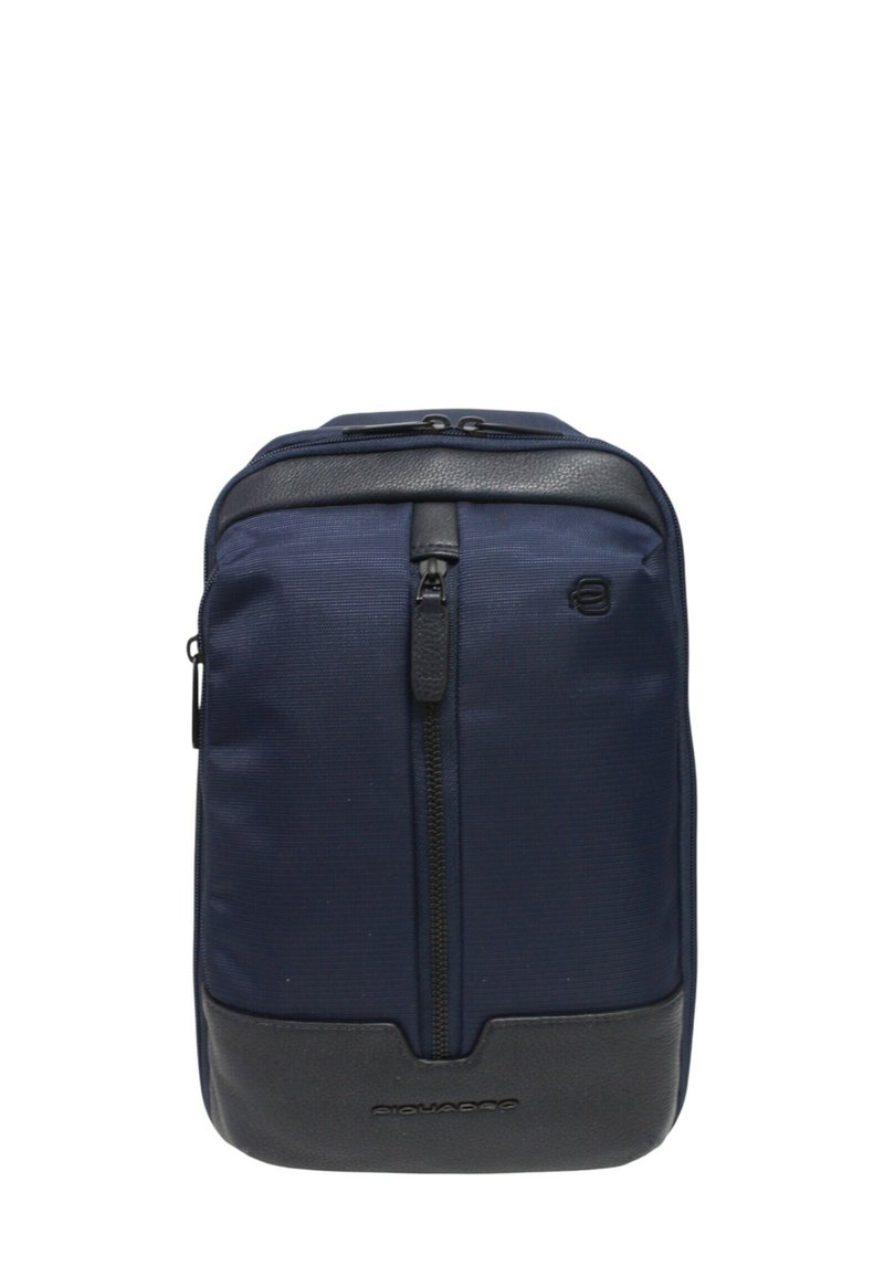 Bolso bandolera compacto azul marino y negro con bolsillo delantero vertical con cremallera y detalles de cuero texturizado.