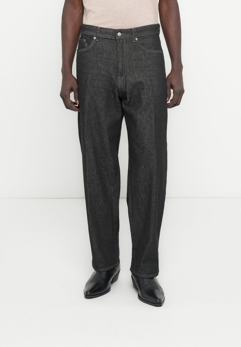 Czarne dżinsy z denimu o prostym kroju, widoczne przeszycia, pięciokieszeniowy fason oraz zapięcie na guzik w pasie.