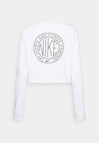 Vit kortärmad skjorta i bomull med rund svart Nike-logo på baksidan, med cirkulär text runt logotypen.