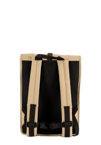 Beige ryggsekk med nettingpaneler på baksiden, justerbare svarte stropper og spenne-lukking, designet for komfort og ventilasjon.