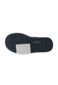 Semelle de chaussure en caoutchouc noir avec un motif en chevrons, dotée d'un insert de talon en caoutchouc texturé blanc et d'un panneau d'accent noir lisse.