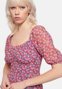 Vestito midi floreale in rosa, con maniche a sbuffo, scollo quadrato e vita arricciata. Tra i punti salienti c'è un vivace motivo floreale e un tessuto leggero.