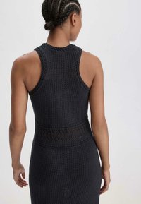 Abito senza maniche grigio scuro con motivo a maglia testurizzato, presenta una vita adatta e un dettaglio in pizzo nella parte centrale.