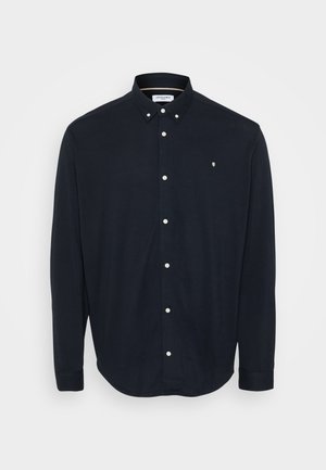 Navy button-up shirt made of soft fabric, featuring a collar, long sleeves, and white buttons along the front. Small logo on the chest.