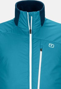 Teal insulated jacket with high collar, white zipper, and a small chest pocket. Features a textured navy accent at the collar.