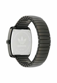 Ruutuline must roostevabast terasest kell linkpaelaga. Tagaküljel on graveeritud Adidas logo ja detailid. Minimalistlik disain ja läikiv viimistlus.