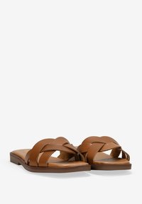 Sandalias de cuero marrón con diseño de tiras entrelazadas y suela plana. Textura suave y diseño de punta abierta.