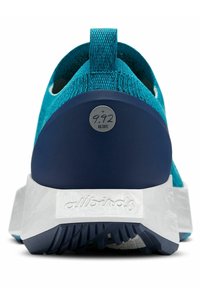 Türkisfarbene Sportschuh mit strukturiertem Strick-Obermaterial, navyfarbenem Fersenbereich und weißer Zwischensohle. Verfügt über ein rundes Etikett mit CO2-Messung.
