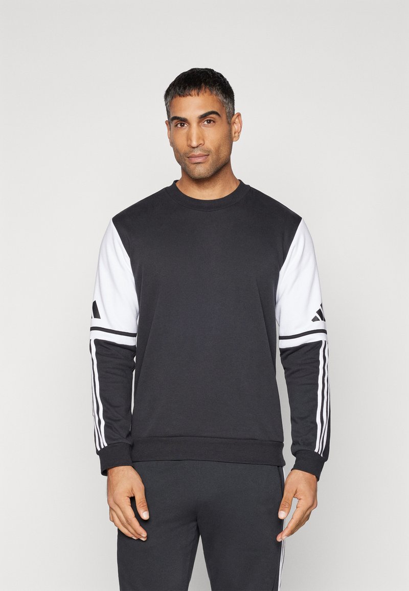 Zwarte sweatshirt met witte mouwen, voorzien van drie strepen langs de armen en een ronde hals. Gemaakt van een katoenmix.