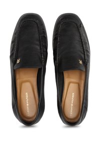 Sorte skinnloafers med en jevn tekstur, med subtile sømdetaljer og en liten gulllogo. Polstret såle synlig.