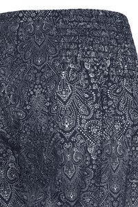 Taille élastique sur tissu foncé avec motif paisley blanc complexe et pointillés, détail froncé sur le côté.