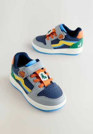 Zilā, pelēkā, zaļā un oranžā krāsā bērnu apavi ar velcro siksniņu, šņorēm un dzīvnieku formu rotājumiem uz siksniņas.
