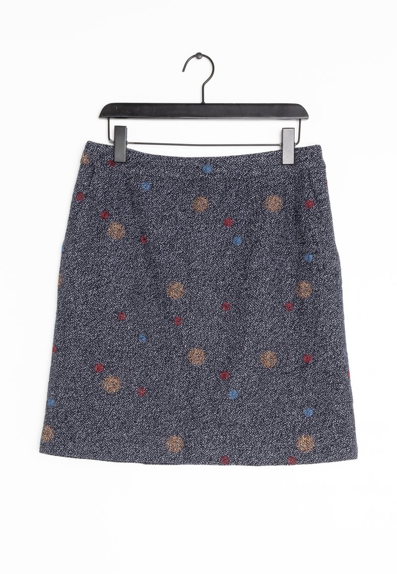 Jupe en tissu tissé de couleur sombre avec un motif texturé, ornée d'accents circulaires multicolores en rouge, bleu et or sur un fond gris.