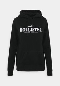Černá mikina s kapucí a přední kapsou, na hrudi s bílým nápisem "Hollister Southern California" a logem racka.