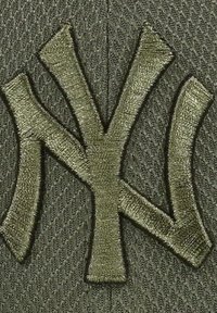 Grüne Kappe mit gesticktem "NY"-Logo in passendem grünen Faden. Die Textur ist aus Mesh, was Atmungsaktivität bietet, und sie hat eine strukturierte Form.