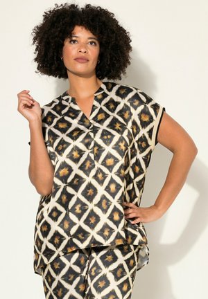 Blouse à manches courtes dans un motif abstrait noir, blanc et doré, avec un col en V et une coupe décontractée avec des fentes sur les côtés.