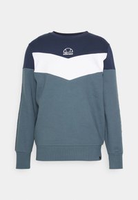 Sudadera de cuello redondo en azul marino, blanco y verde azulado. Presenta un diseño de Chevron, puños acanalados y un pequeño logo en el pecho. Textura de tela suave.