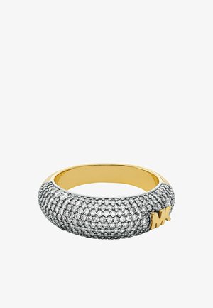 Silverfärgad ring med en texturerad yta och gnistrande detaljer, en slät guldinteriör och ett präglat guld "MK"-logotyp.