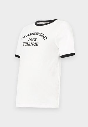 Balta T-kreklu ar melnu apkakles un piedurkņu akcentu, kurā ir teksts "MARSEILLE 1975 FRANCE" izliekta melnā fontā.