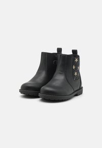 Bottes de cheville en cuir noir avec panneaux élastiques sur les côtés et un accent à motif étoilé. Bout arrondi et semelle texturée pour une meilleure adhérence.