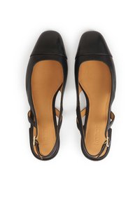 Black leather slingback shoes with a square toe, feature cut-out sides, and a tan insole. Detailing includes a small side buckle.