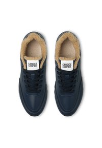 Námořnické modré kožené tenisky se světlým umělým kožíškem, černými tkaničkami a viditelnou nálepkou loga na jazyku. Zaoblený tvar s měkkou podešví.