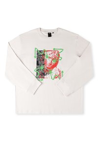 Camiseta blanca de manga larga con un estampado gráfico que presenta acentos rojos y verdes, diseño abstracto y un fondo negro con patrones.