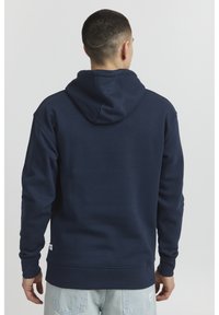 Navy blue hoodie with a kangaroo pocket, ribbed cuffs, and hem. Features a drawstring hood and is made of soft fabric.