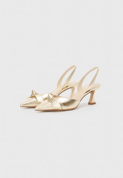 Metallic gold slingback heels with pointed toes, knot detail at the front, and a slender, angled heel. Smooth texture and minimalistic design.