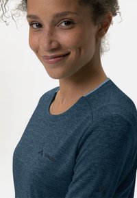 Mørkeblå sportsskjorte med heathered tekstur, rund halslinning og subtile logodetaljer, med lyseblå accenter på kragen.