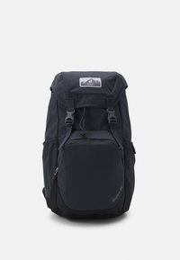 Sac à dos noir avec des bretelles réglables, un rabat supérieur, une poche zippée à l'avant et des poches en mesh sur les côtés. Fabriqué en tissu durable avec une texture lisse.