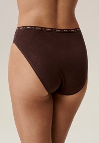 Brązowe bawełniane figi z wysokim stanem o gładkiej fakturze, z kontrastującym czarnym paskiem w talii z nazwą marki "ATLANTIC" w drobnym druku.