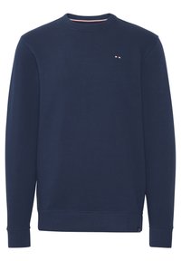 Sweat-shirt bleu marine à manches longues avec col ras-du-cou, poignets et ourlet côtelés, arborant un petit logo rouge, blanc et bleu sur la poitrine.