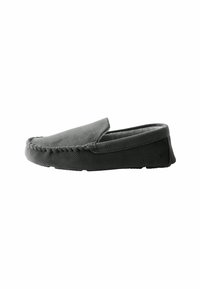 Chaussure grise à enfiler avec surface texturée, bout rond et semelle noire contrastante. Présente des coutures visibles le long du bord. Doublure intérieure douce.
