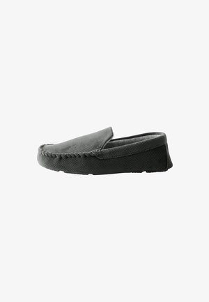 Grey slip-on shoe with textured surface, rounded toe, and contrasting black sole. Features visible stitching along the edge. Soft interior lining.