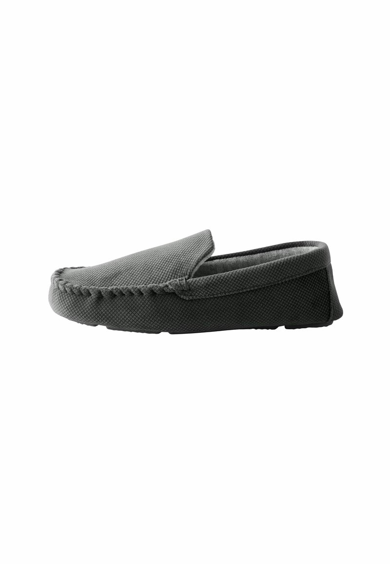 Chaussure grise à enfiler avec surface texturée, bout rond et semelle noire contrastante. Présente des coutures visibles le long du bord. Doublure intérieure douce.