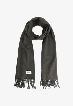 Tummanharmaa villahuivi, jossa on hapsutetut päät, pehmeä texture ja pieni etiketti, jossa on brändin nimi. Suorakaiteen muotoinen, roikkuu huolettomasti.