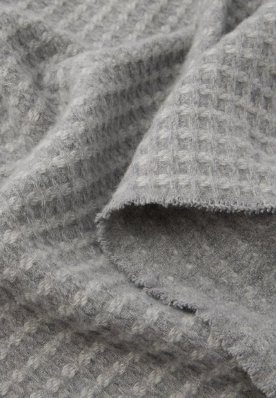 Hall on tekstuuriga hall kangas, millel on kangast muster ja kergelt kulunud äär, esitades pehmeid kiude ja mugavat välimust.