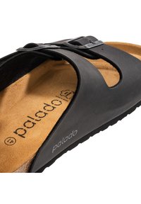 Sandal nero con fibbia regolabile, dotata di una suola testurizzata e di una parte superiore liscia e sagomata. Logo del marchio stampato sulla suola.